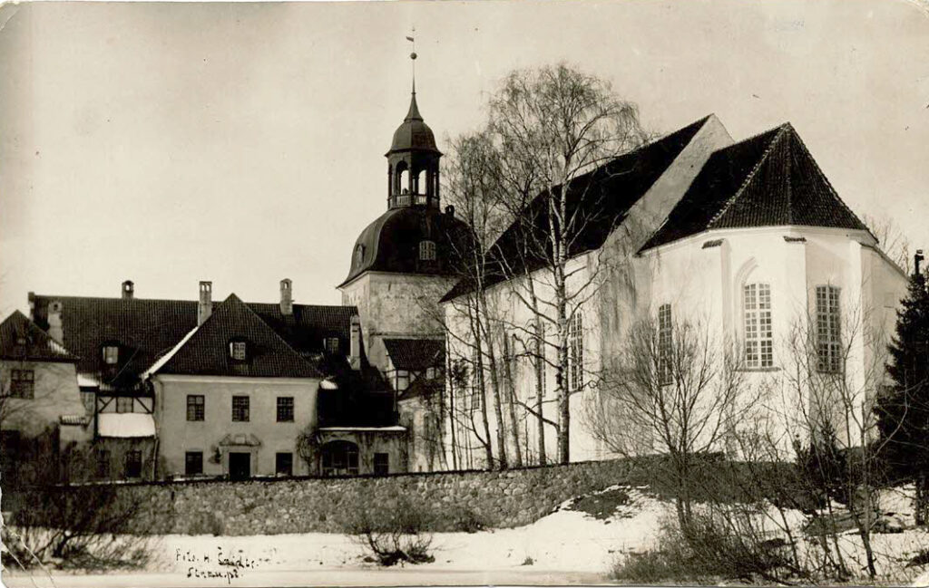 Lielstraupes pils. Centrā pils vecākā daļa – tornis. Labajā pusē priekšplānā – baznīca. Ap 1930. gadu. Fotogrāfs nezināms.