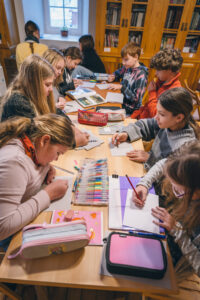 Skolēni pēta pastkartes Turaidas muzejrezervātā